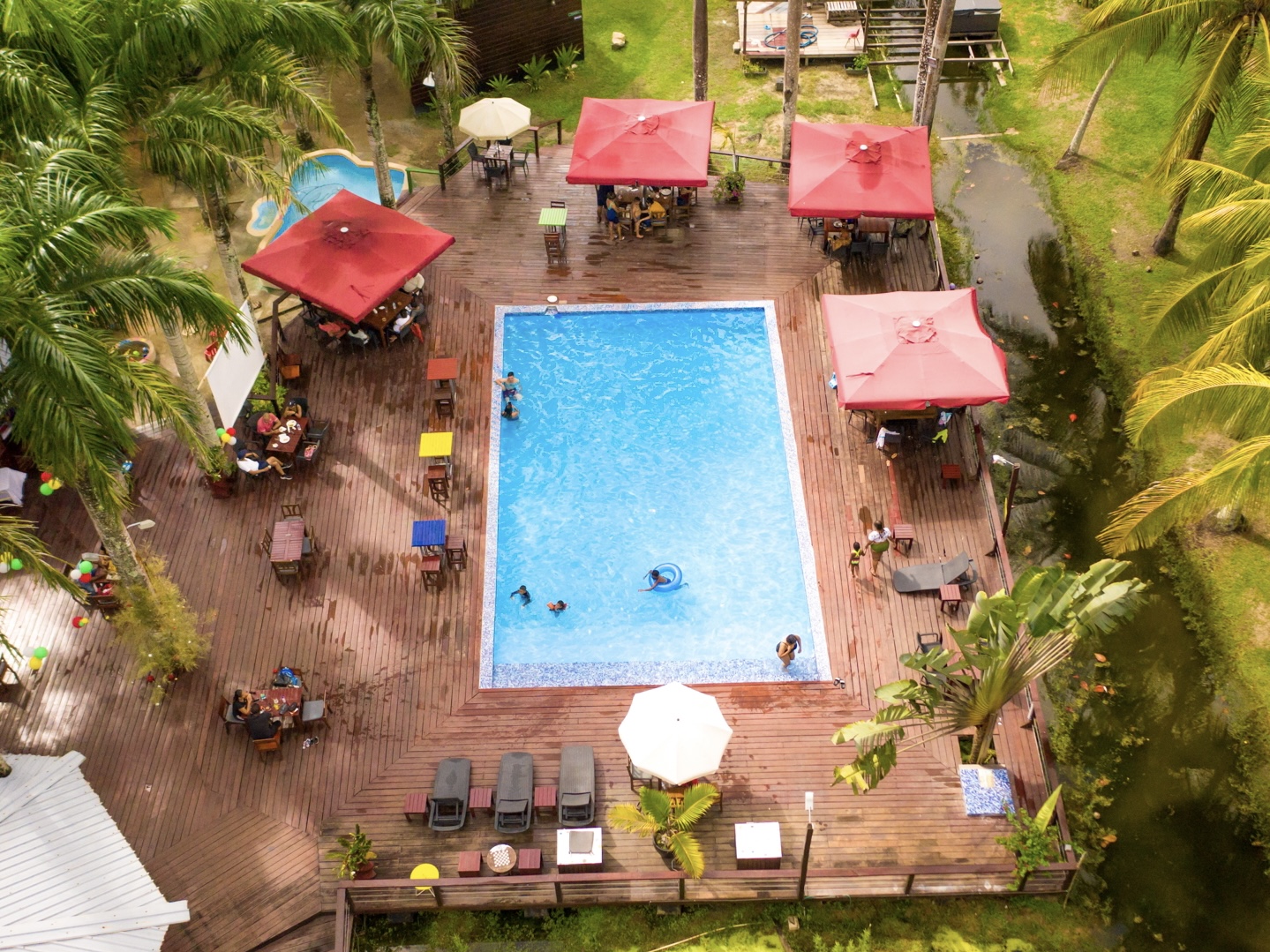 Accommodatie Suriname, Frederiksdorp, balkon uitzicht rivier, zwembad met ligbedden